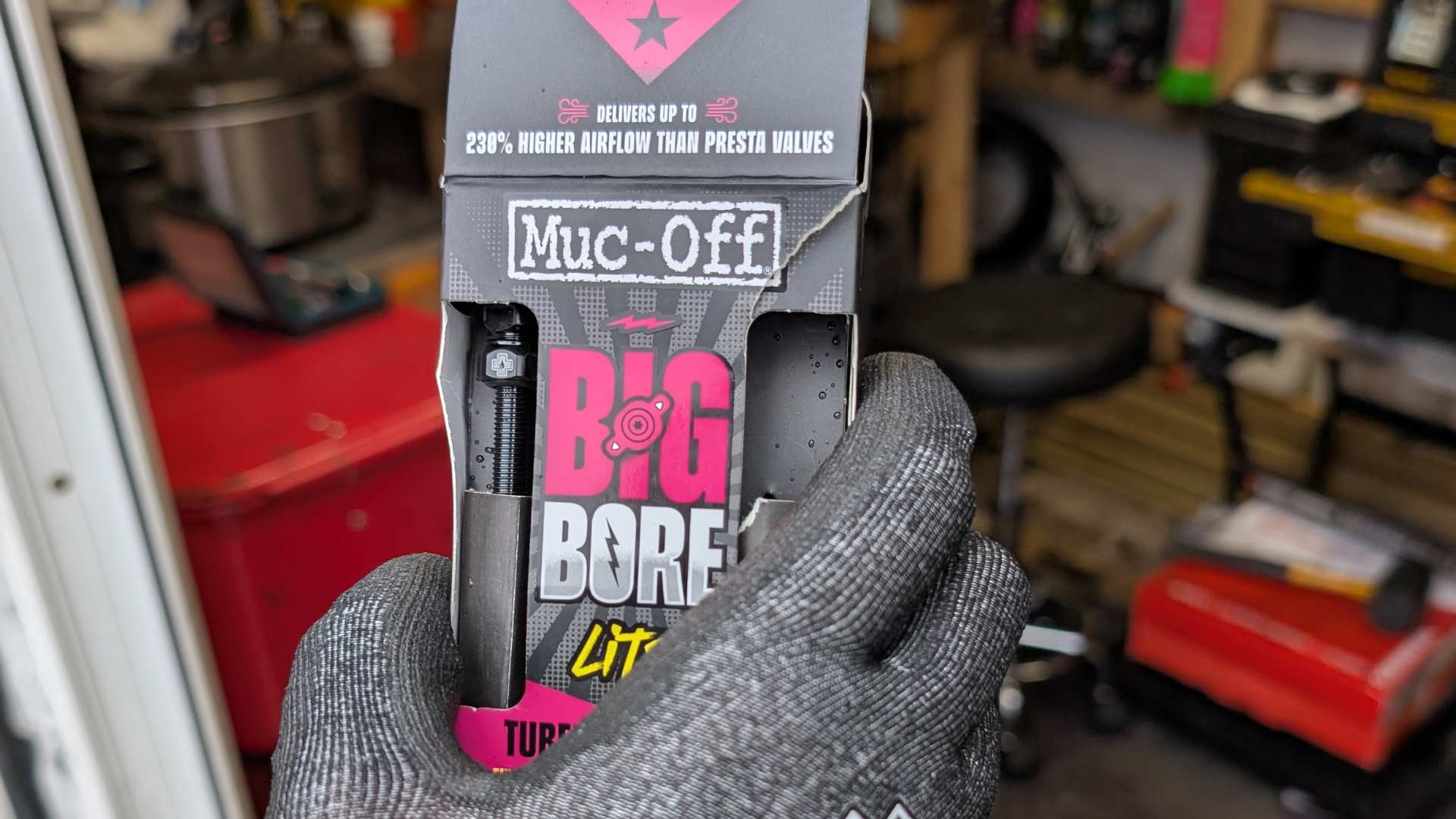 product review - muc off big bore. picture showing a hand holding an opened box of big bore tubeless valves